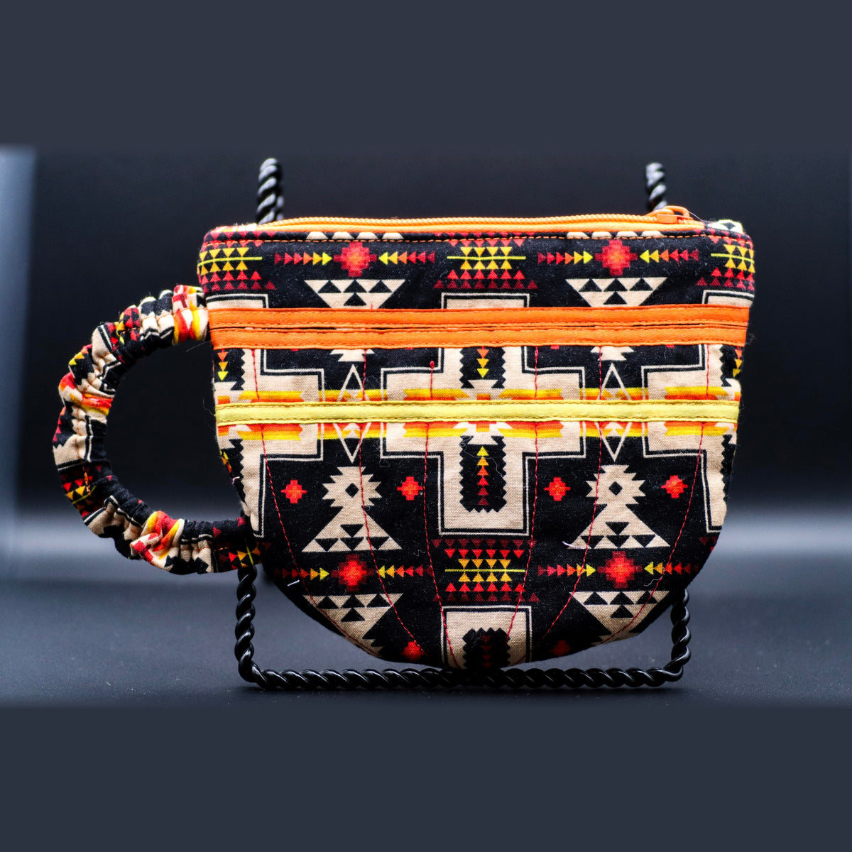Teacup-shaped quilted bag in black with cream geometric pattern, front view