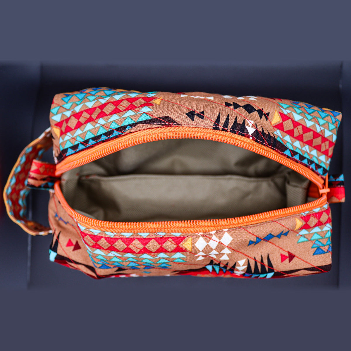Inside of the tan geometric boxy bag: grey lining