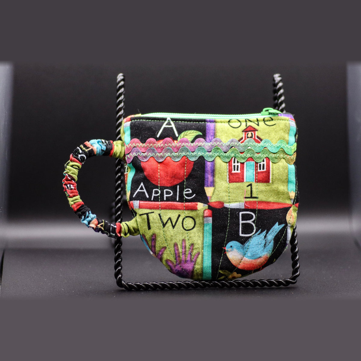 Teacup-shaped quilted bag in a multicolor alphabet print, front view