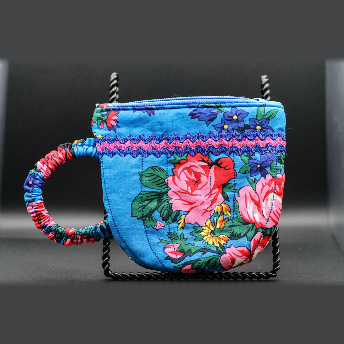 Teacup-shaped quilted bag in blue with pink roses, front view