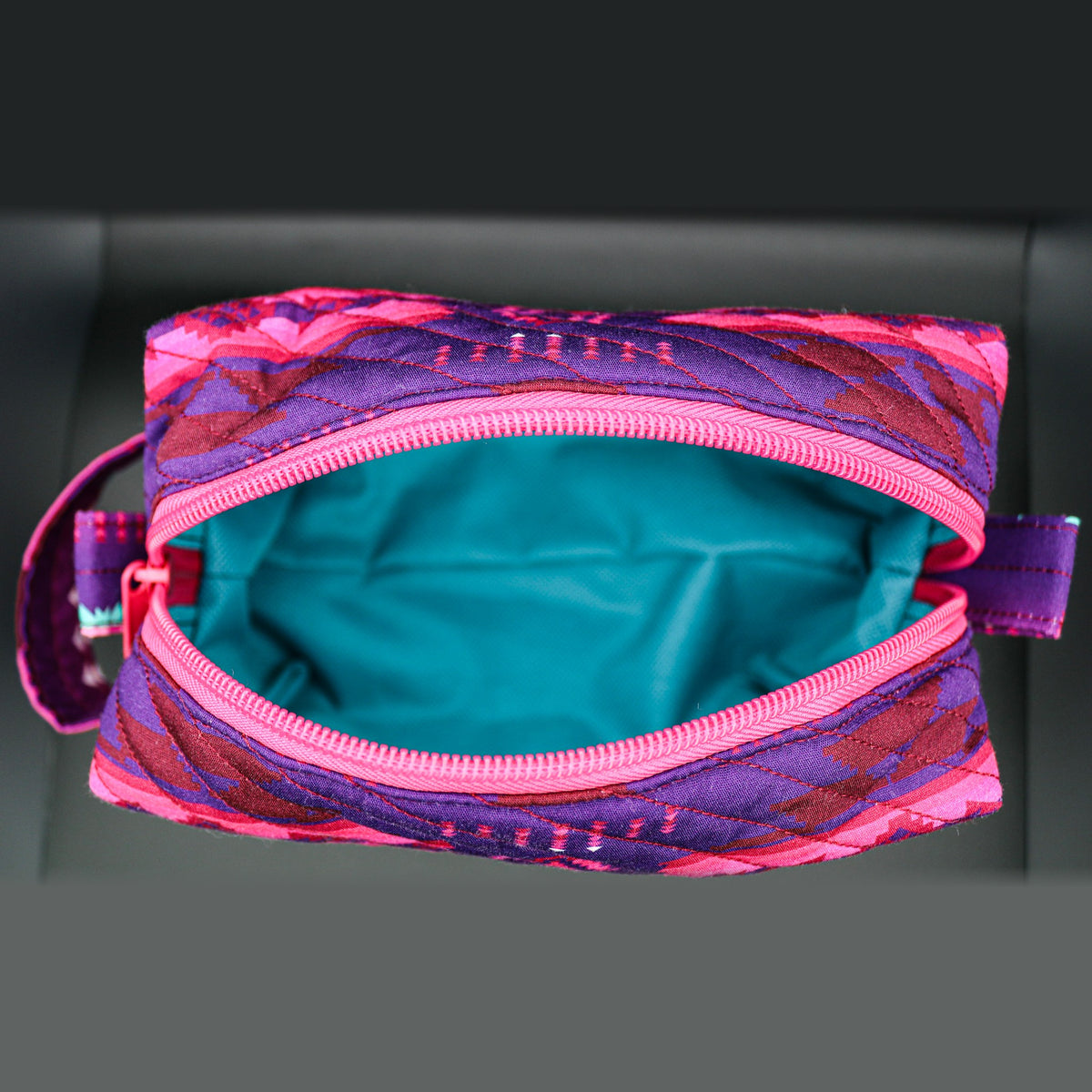 Inside of the pink and purple boxy bag: teal lining