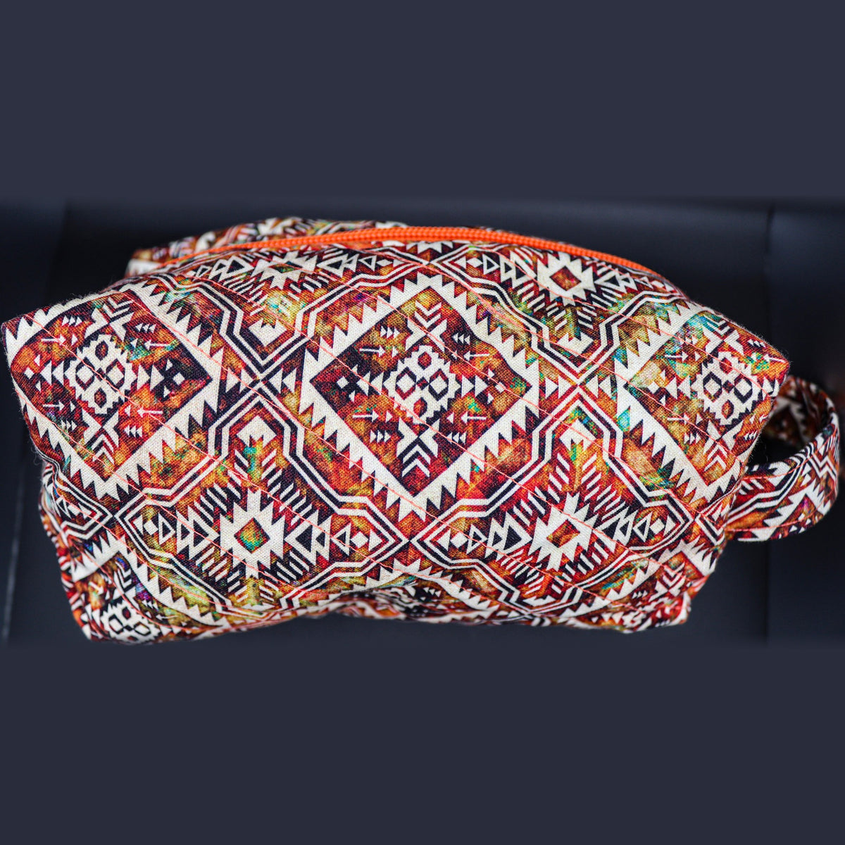 Boxy quilted bag in a rust and cream diamond print, front view