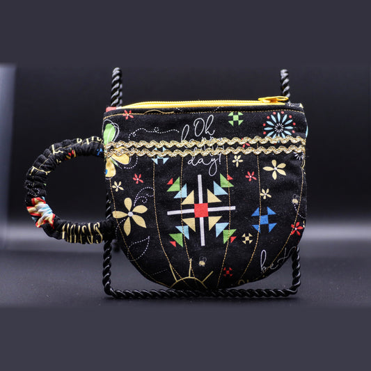 Teacup-shaped quilted bag in black with a floral print, front view