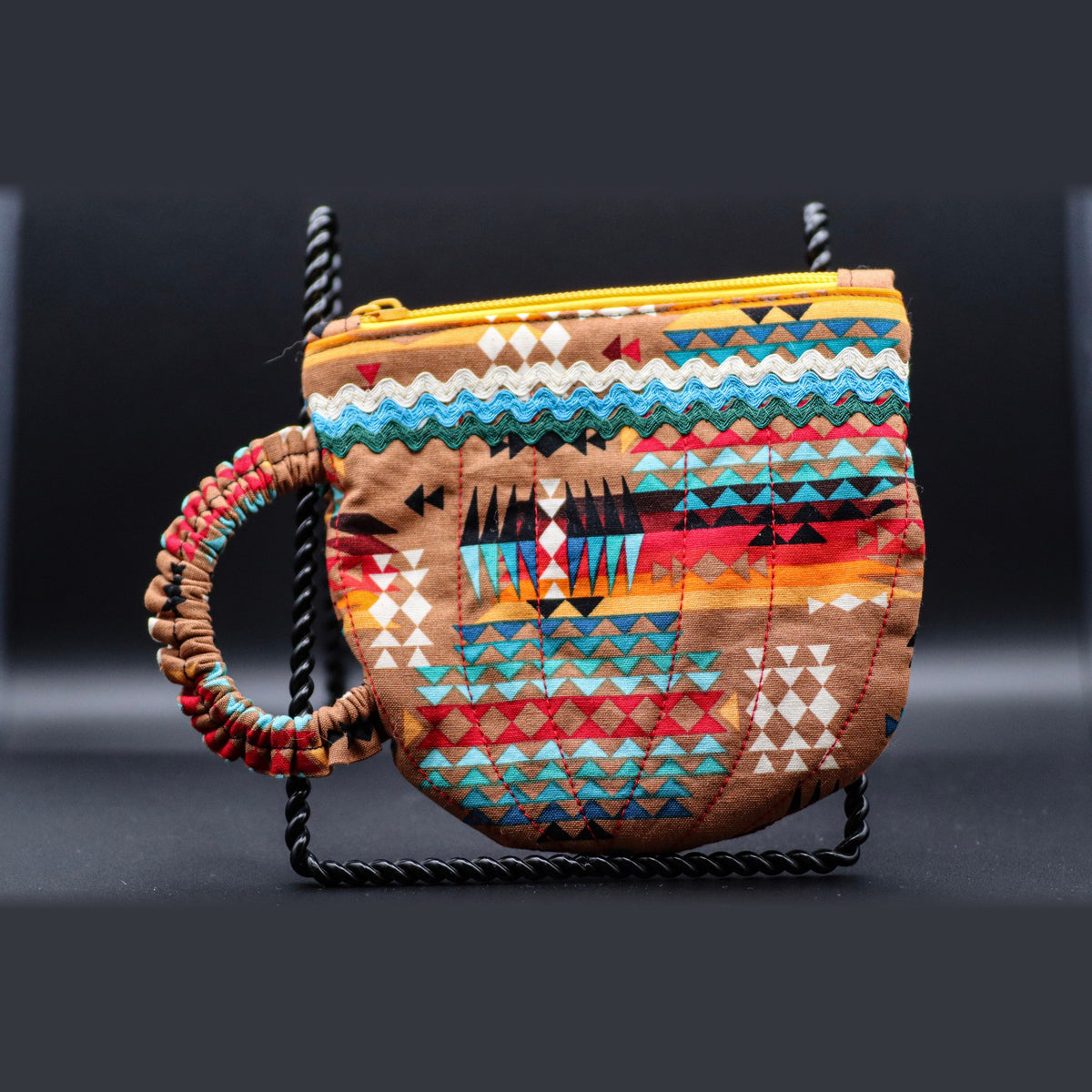 Teacup-shaped quilted bag in tan with turquoise bands, front view